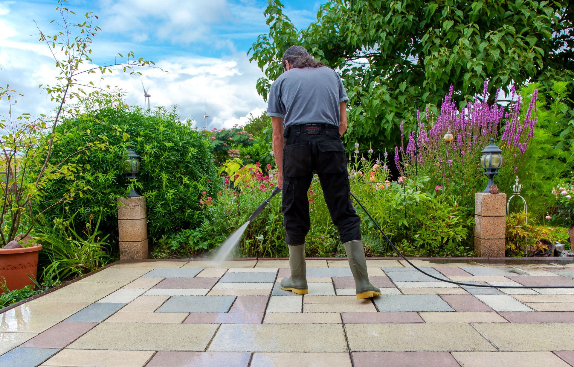 Cleaning stone slabs on patio with the high-pressure cleaner.